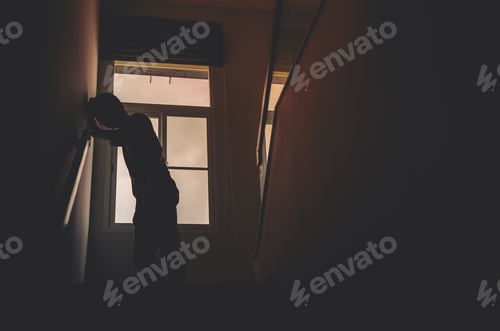 Preview: Alone Man Silhouette Standing At The Window Closed In Dark Home. Man Stands At Window Alone