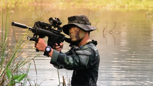 Preview: Soldier With A Rifle.Army Soldier In Protective Uniform Holding Rifle And Standing In Water.Special