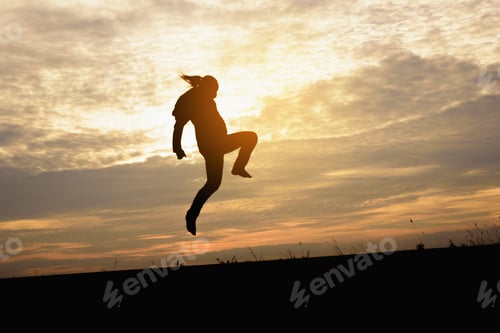 Preview: A Silhouette Of Man Jumping In The Sunset Background.
