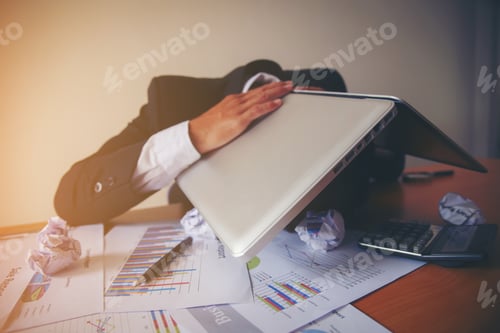 Overworked Business Person Leans Head on Laptop
