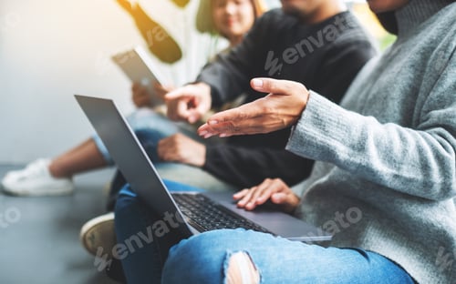 Preview: A Group Of Young People Sitting And Using Laptop Computer And Digital Tablet Together