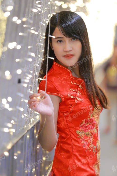 Preview: The Beautiful Lady In Chinese Dress With Light Bulb Background. Happy Chinese New Year Concept.