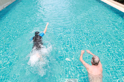 Preview: High Angle View Happy Elderly Caucasian Husband And Elderly Asian Wife Swimming In Pool During