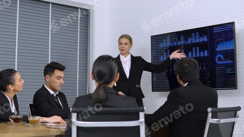 Preview: Business Girl Explaining Graph On Monitor Screen To The Colleagues In Meeting Room.