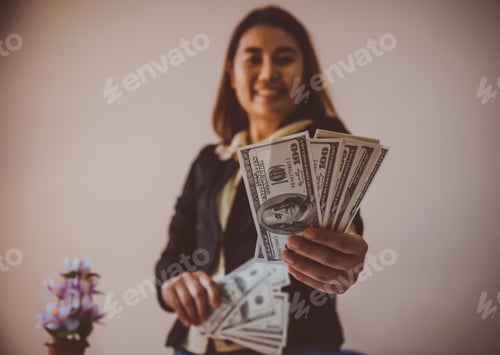 Preview: Businesswoman Displaying A Spread Of Cash Over A Green Vintage Background
