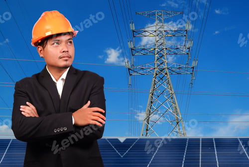 Preview: Engineer Man With Solar Panel Against High Voltage Towers Background.