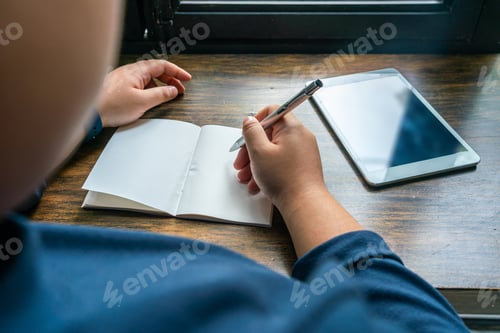 Preview: Rear View Of Woman Hand Using Pen And Writing Notebook