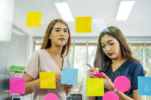Preview: Young Women Collaborating with Sticky Notes at Workplace
