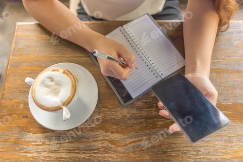 Preview: Top View Of Female Hand Writing Note And Using Smartphone