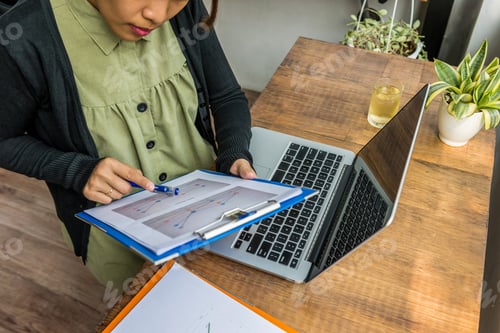 Preview: Asian Millennial Working On Diagram Document Next To Laptop