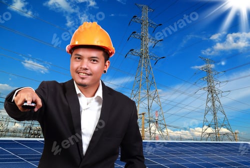 Preview: Engineer Man With Solar Panel Against High Voltage Towers Background.