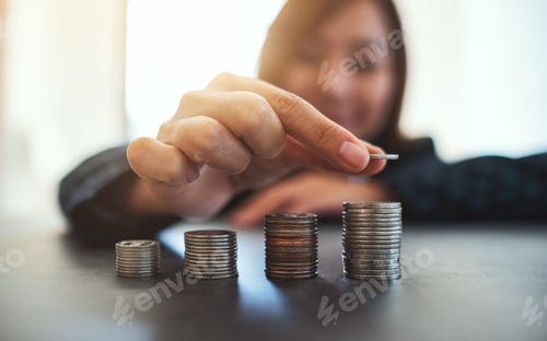 Preview: Businesswoman Holding And Stacking Coins On The Table