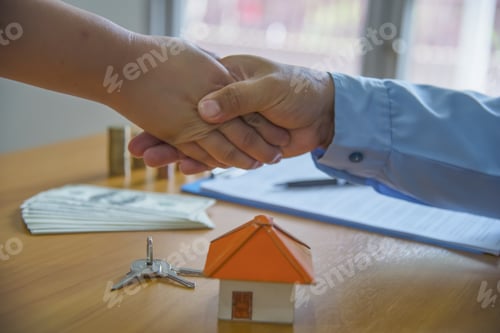 Preview: Estate Agent Shaking Hands With Customer After Contract Signatur
