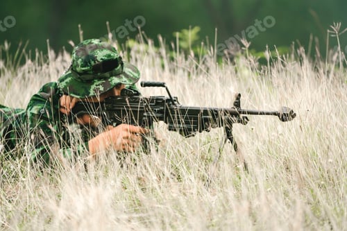 Preview: Soldier Lying On The Ground And Camouflage In Grass. Soldier Holding Gun Weapon And Waring Armor