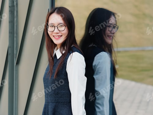 Preview: Portrait Of Beautiful Young Brunette Smiling Woman In Black Dress In Front Of Mirror. Outdoor