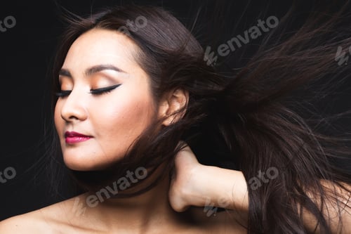 Preview: Portrait Of Young Asian Woman With Makeup Long Hair On The Black Isolated Posing.