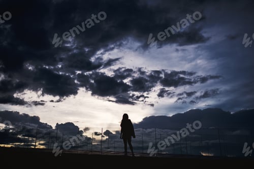 Preview: Silhouette Image Of A Woman Standing Alone With Sunset Cloudy Sky