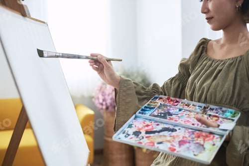 Preview: An Asian Woman Who Loves Art Or A Female Artist Is Holding A Paint Palette And Paintbrushes While