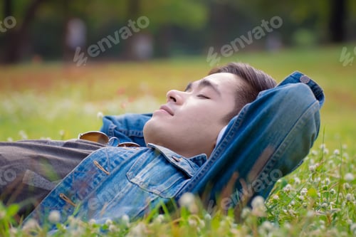 Preview: Freedom Lifestyle,Young Man Relaxing In The Park .Young Man Lying On A Grass And Listens To Music