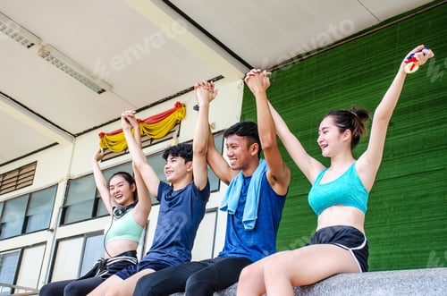 Preview: Group Of Young Sporty People Cheer Up And Laughing Together Sitting In Stadium After Workout