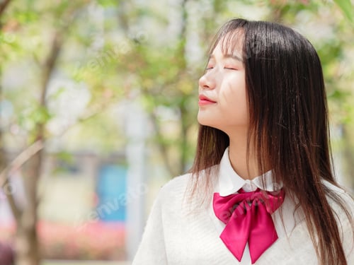 Preview: Portrait Of A Beautiful Chinese Girl Enjoy Sun Light And Floral Fragrance With Eyes Closed.