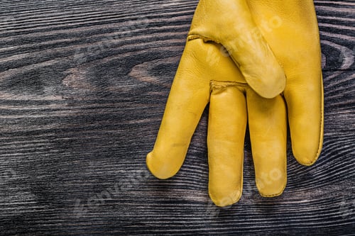 Preview: Leather Yellow Protective Glove On Vintage Wooden Board Maintenance Concept.