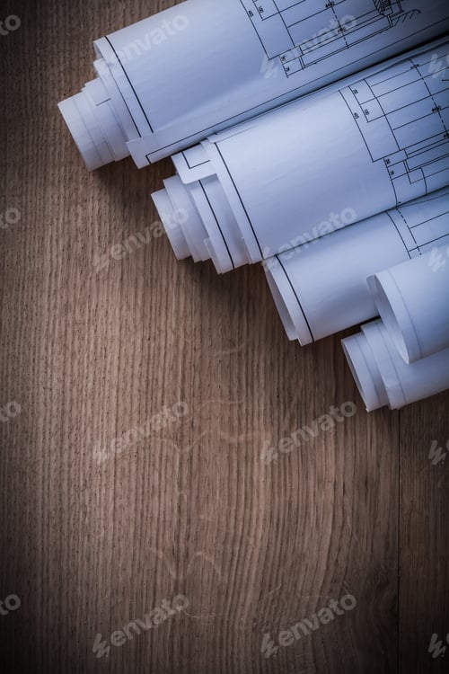 Preview: Stack Of Rolled Blueprints On Wooden Background Construction Concept.
