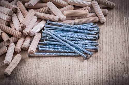 Preview: Heap Of Wood Dowels And Construction Nails On Wooden Background.