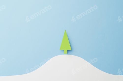 Preview: Small Paper Christmas Tree Cut From Green Paper Over Blue Background