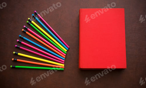 Preview: Wooden Writer Desktop With Colorful Pencil And Red Empty Cover Book