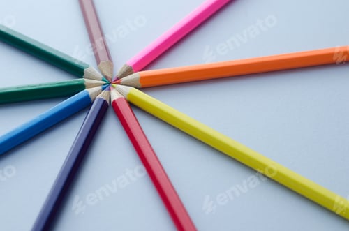 Preview: Wooden Colored Crayons In A Circle Over Blue Background
