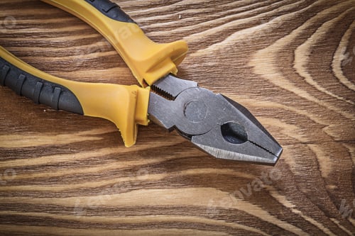 Preview: Gripping Tongs On Vintage Wooden Board Directly Above Construction Concept.