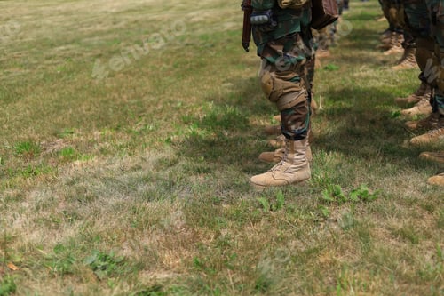Preview: Legs Of Real Soldiers In Military Boots And Clothes Standing In Formation On The Grass. Background