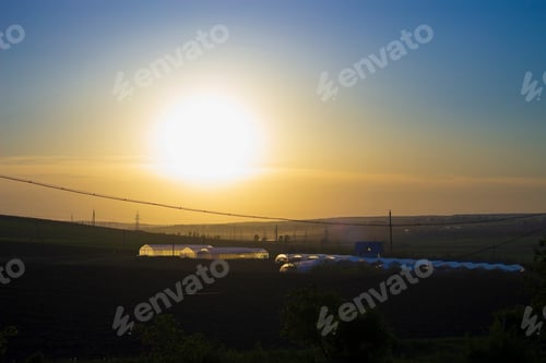 Preview: Silhouettes Of Greenhouses At Sunset. Beautiful Background Theme Of Natural Products, Vegetables
