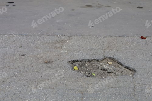 Preview: A Hole In The Destroyed Asphalt In A Park On A Jogging Or Bike Path. Urban Environment In Need Of
