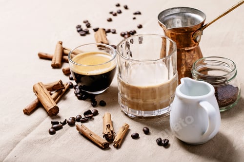 Preview: Fresh Coffee In Glass Cups With Cinnamon Sticks Over Brown Cloth Background. Top View, Flat Lay