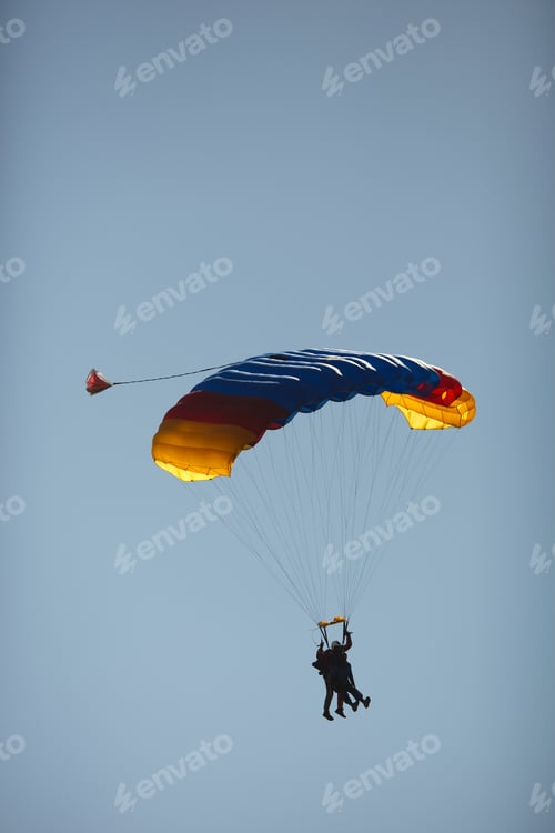 Preview: Silhouettes Of An Instructor And A Passenger Under A Bright Canopy Of A Parachute During A Tandem