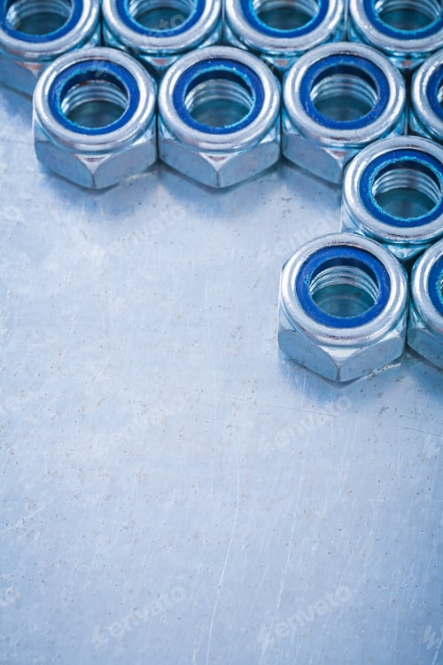 Preview: Threaded Screw Nuts On Metallic Background Copy Space Image Construction Concept.