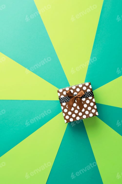 Preview: Christmas Gift Box Over Geometric And Colorful Background, Above View. With Space For Text Or Other