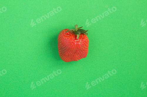 Preview: Ugly Food. One Strawberry In The Center Of The Green Background. Top View. Copy Space.