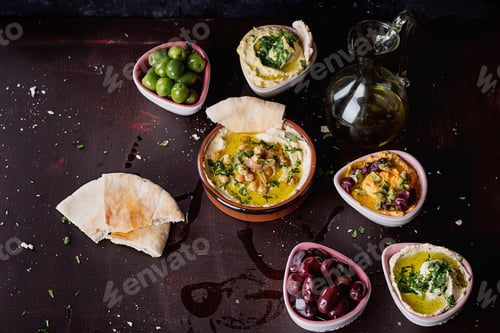 Preview: Variety Of Middle East Meze: Different Types Of Hummus Served With Olives And Pita Bread.