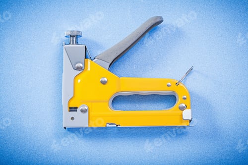 Preview: Construction Stapler On Blue Background Horizontal View.