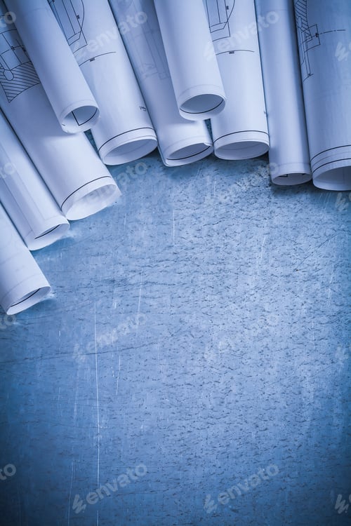 Preview: Variation Of Rolled Up White Construction Plans On Scratched Silver-Metal Surface Building And