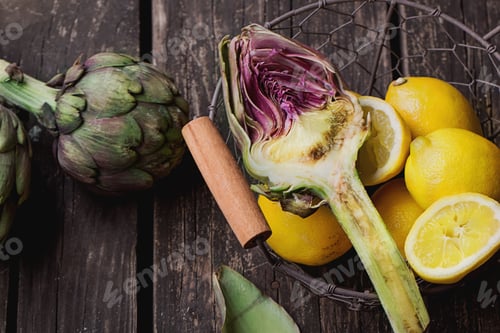 Preview: Ripe Organic Artichokes On The Rustic Wooden Board With Lemon, Napkin And Knife