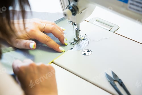 Preview: Woman Hands With Fabric At Sewing Machine. Seamstress Working Behind Her Equipment. Tailoring