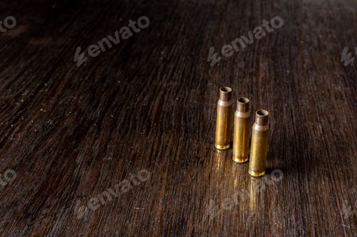Preview: Empty Bullet Casings On A Dark, Wooden Table.