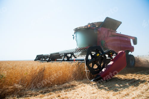 Preview: Agriculture. Combine Harvester On A Wheat Field With Blue Sky