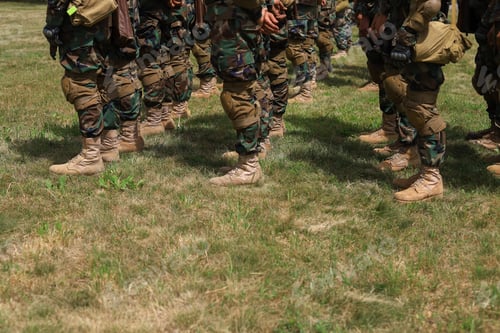 Preview: Legs Of Real Soldiers In Military Boots And Clothes Standing In Formation On The Grass. Background