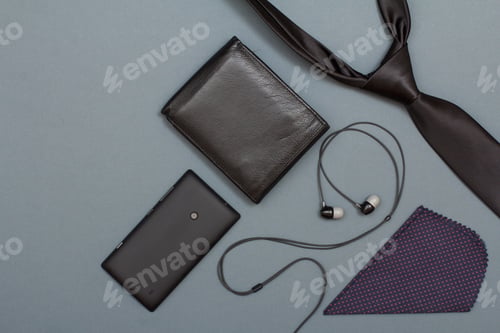 Preview: Mobile Phone, Headphones, Leather Purse, Handkerchief And Necktie On Grey Background. Accessories
