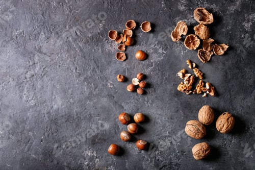 Preview: Varieties Of Nuts: Hazelnuts And Walnuts Over Dark Texture Background. Top View, Flat Lay. Copy